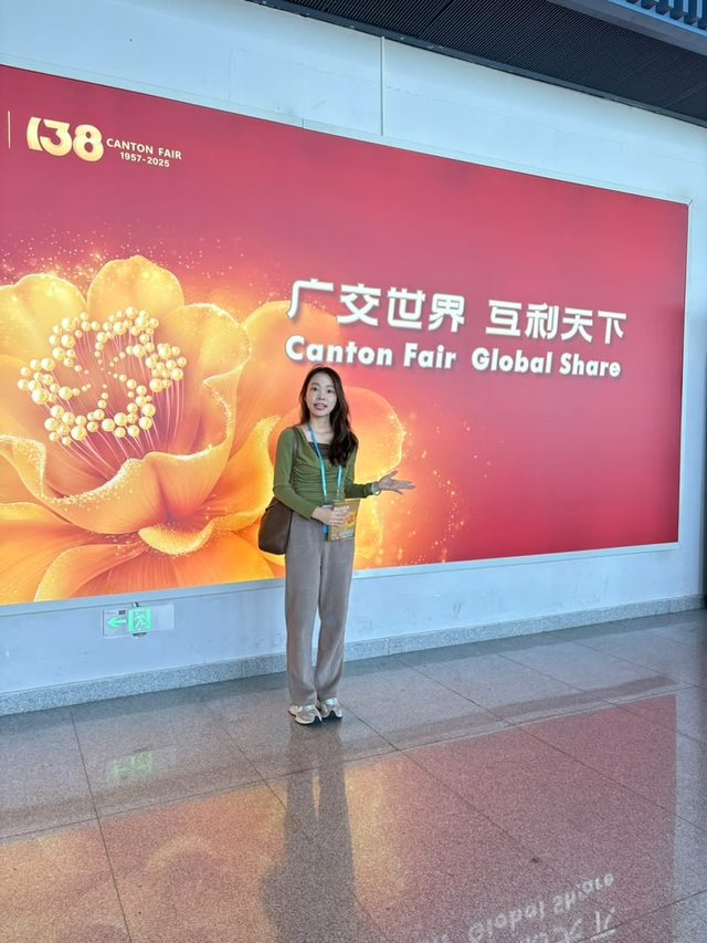 Shirley Chou standing in front of the 138th Canton Fair “Canton Fair Global Share” banner in Guangzhou