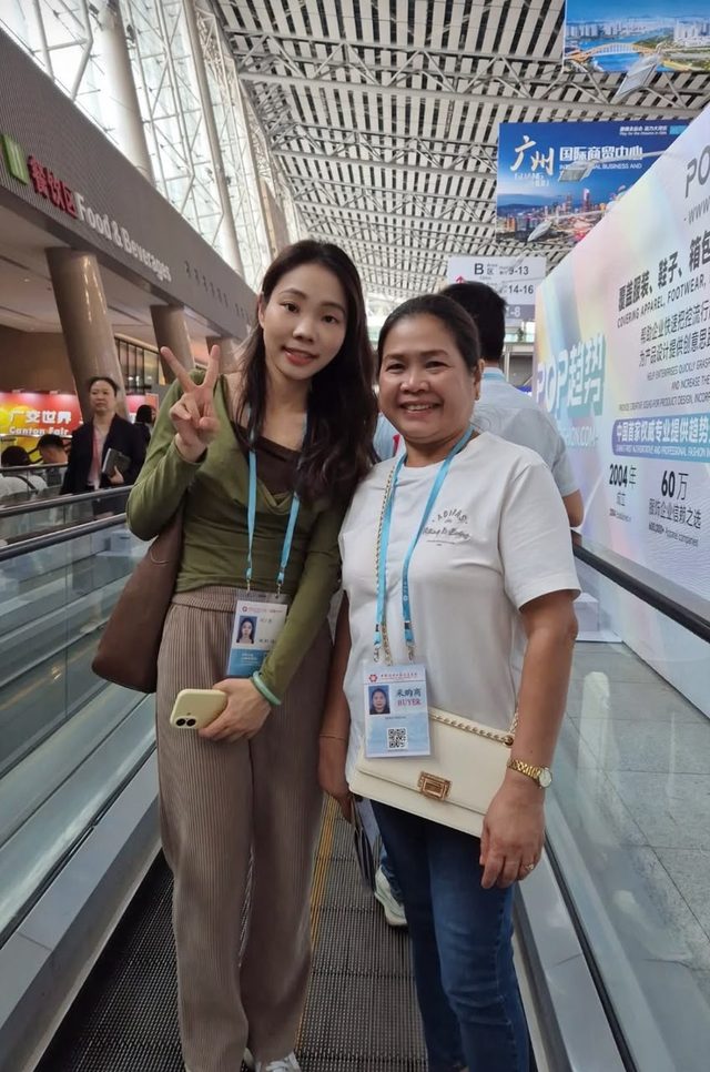 Shirley Chou riding an escalator with an overseas buyer inside the Canton Fair exhibition complex
